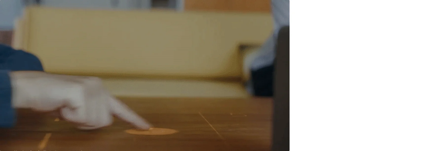 A finger arriving on a projected point on a wooden table